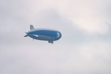 A tourist airship with passengers on board travels through the sky. clipart