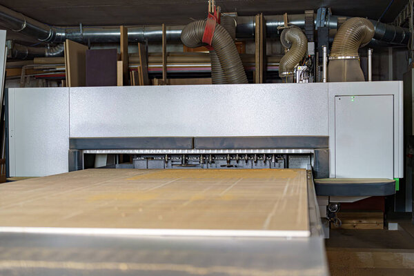 Фрезы на деревообрабатывающей машине с ЧПУ в столярном цехе. Фабрика по производству мебели.