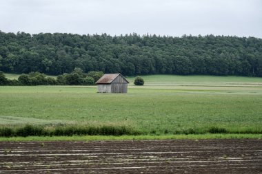 Yeşil tarladaki bir çiftçi için büyük ahşap bir ahır..
