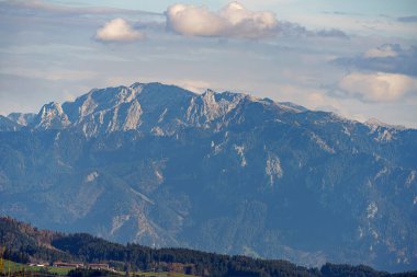 Bulutlu bir gökyüzüne karşı Alplerin karla kaplı zirveleri.