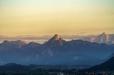 Bulutlu bir gökyüzüne karşı Alplerin karla kaplı zirveleri.