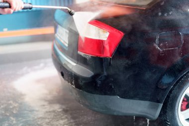 Yüksek basınçlı bir çamaşır makinesinde su ve köpükle arabayı temizleme ve temizleme. Yıkandıktan ve temizlendikten sonra arabayı temizle..