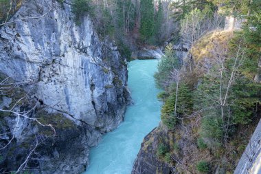 Turkuaz su sarp kayalıkların arasından esiyor. Etrafı yemyeşil kayalıklarla çevrili. Göz kamaştırıcı bir doğal manzara yaratıyor. Güneş ışığı nehirden yansıyarak onun canlı rengini vurgular..