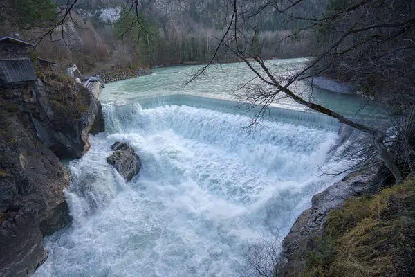 Nefes kesici bir şelale durgun bir turkuaz nehrine dökülür ve muhteşem bir manzara yaratır. Uçurumların ve ağaçların etrafındaki doğal güzellikleri artırır..