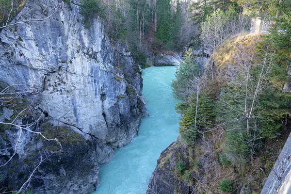 Turkuaz su sarp kayalıkların arasından esiyor. Etrafı yemyeşil kayalıklarla çevrili. Göz kamaştırıcı bir doğal manzara yaratıyor. Güneş ışığı nehirden yansıyarak onun canlı rengini vurgular..
