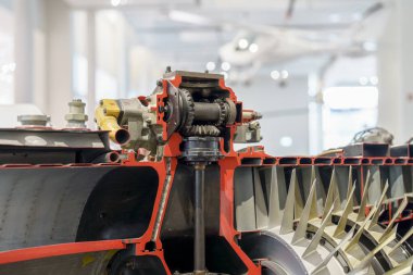 Sergi sergilerindeki bir jet motoru karmaşık iç bileşenler ve mekanizmalar sergiliyor. Sergide bir müze ortamında mühendislik yeniliği ve havacılık teknolojisi vurgulanıyor.