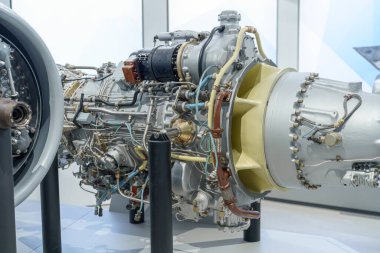 Gelişmiş bir jet motoru karmaşık tasarım ve mühendisliğini bir uzay ticaret fuarında sergiliyor. Katılımcılar sergilenen teknolojiye hayran kalarak, havacılıktaki yeniliğin altını çiziyorlar.