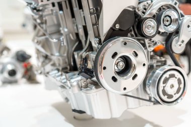 Modern bir içten yanmalı motorun yakından incelenmesi, karmaşık bileşenlerini ve cilalanmış metal yüzeylerini vurguluyor. Motorun karmaşık tasarımı mühendislik işçiliğini vurguluyor.