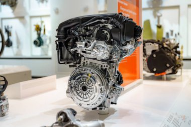 Bir otomotiv sergisinde sergilenen modern bir motorun ayrıntılı bir görüntüsü gelişmiş mühendislik ve bileşenleri vurguluyor. Bu kurulum araç tasarımında yeniliğin önemini vurgular.