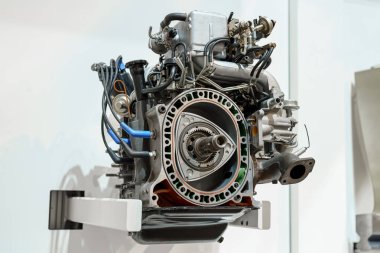 Karmaşık bir döner motor duvara monte edilir, karmaşık bileşenleri ve mühendislik tasarımı vurgulanır. Bu ekran, bu eşsiz motor tipinin arkasındaki yeniliği gösteriyor.