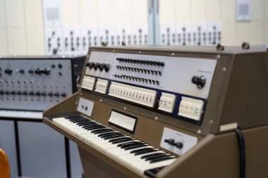 Eski bir sentezleyici diğer elektronik enstrümanlarla çevrili bir müzik stüdyosunda belirgin bir şekilde yer alır. Kurulum müzisyenleri ses oluşturma ve müzik üretimini keşfetmeye davet ediyor..
