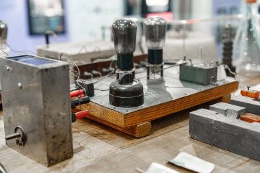 Vakum tüpleri ve ahşap bir zeminde elektrik tesisatının yer aldığı klasik elektronik aletlerin detaylı bir görüntüsü. Kurulum, bir müze ortamında devre ve teknolojinin gelişimini vurguluyor.