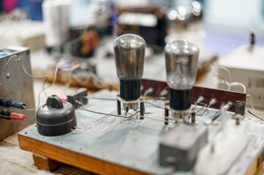 Bu atölyede vakum tüpleri ve karmaşık devreler de dahil olmak üzere antika elektronik bileşenler yer alıyor, 20. yüzyıl ortasındaki teknolojinin işçiliğini vurgulayan bir retro ayar..