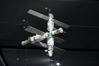 Bir bilim sergisinde tavandan uzay istasyonunun detaylı bir modeli askıya alınır. Ziyaretçiler, sergiyle uğraşırken uzay keşiflerinin arkasındaki teknoloji ve mühendisliğe hayranlık duyuyorlar..