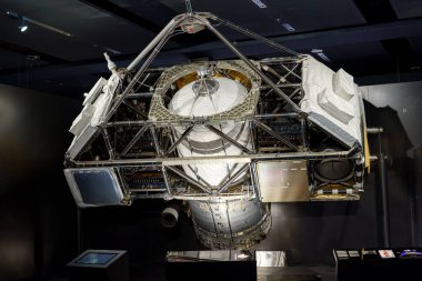 Ziyaretçiler, bir müzede sergilenen ve astronomik araştırma ve keşifler için kullanılan karmaşık tasarımı ve gelişmiş teknolojisini vurgulayan bir uzay teleskobunu keşfediyorlar..
