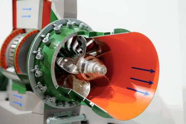 Karmaşık bir jet motoru modeli, bir teknoloji ve mühendislik vitrininde türbini, pervane bıçaklarını ve oda tasarımını vurgulayan dahili yapıları gösterir. Ziyaretçiler işçiliğe hayran..