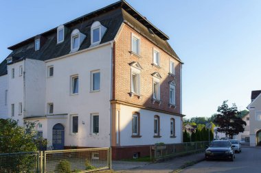 İki caddenin kesişiminde, eşsiz mimari öğeler barındıran büyüleyici bir konut binası bulunuyor. Öğleden sonra güneş ışığı ön cepheye sıcak bir hava katar ve karakterini geliştirir..