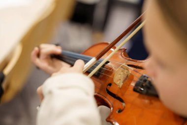 Genç bir müzisyen bir müzik sınıfında keman çalmaya odaklanır. Toplum merkezinin sıcak atmosferi öğrenme deneyimini arttırır..