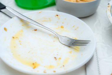 Boş tabak, yemek artıkları ve masada tek bir çatal kalmış. Sıradan bir yemek atmosferi yemeğin az önce bittiğini gösteriyor..