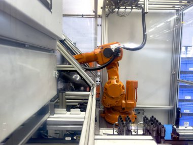 Endüstriyel bir robot aktif olarak modern bir üretim hattındaki görevlerle meşgul..