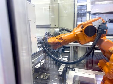 Bir robotik kol, yüksek teknolojili üretim ortamında bileşenleri birleştirmede ustalıkla çalışır. Odak noktası karmaşık hareketleri ve hassas görevleri..
