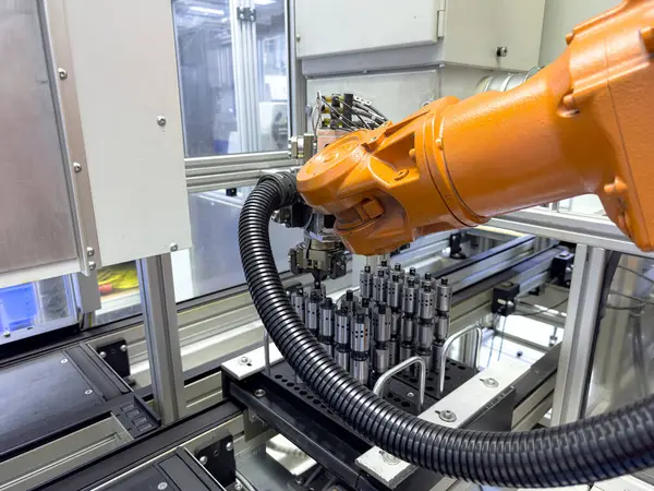 Robot bir kol, modern bir üretim tesisi içinde yüksek hassasiyetli bileşenlerin montajında kullanılıyor. Çevre verimlilik için otomatik sistemlerle yapılandırılmıştır..