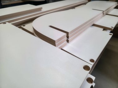 Bir zanaat atölyesinde, düzgün kesilmiş ahşap parçalar montaj için hazırlanır, kaliteli malzemeler ve hassas üretim teknikleri sergilenir. Atölyede detaylara önem veriliyor.