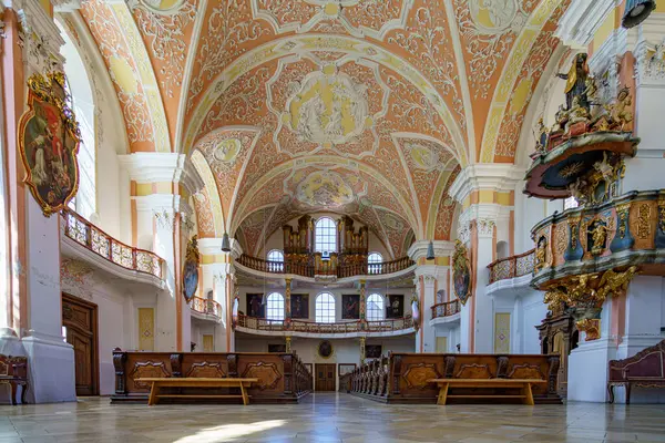 Karmaşık barok tarzı kilisenin iç mekanı parlak gün ışığı altında sergileniyor. Detaylı freskler, ahşap sıralar ve zarif bir sunak sergileniyor. Huzurlu bir tefekkür ve yansımayı davet ediyor..