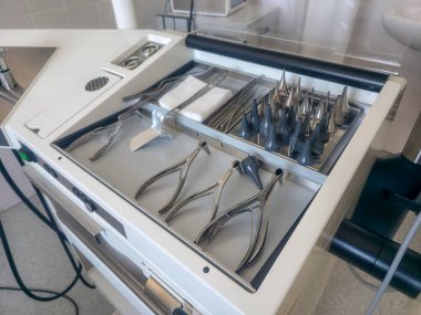 Sterilize bir ortamda tıbbi bir tepside birden fazla cerrahi alet düzenlenir. Ayarda çeşitli prosedürler için uygun bir klinik tasarım yer alıyor ve hasta güvenliğini artırıyor.