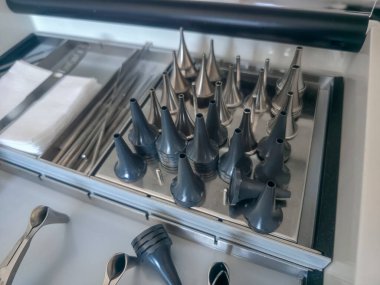 Bir çekmecede düzgünce düzenlenmiş sayısız metal ve plastik huni, çalışma ortamında belirli ölçümler ve uygulamalar için çeşitli boyutlarda sergilenmektedir..
