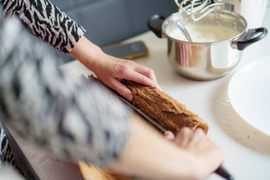 Bir insan sıcak bir mutfakta, malzemelerle mutfak malzemelerini karıştırıp hazırlıyor. Sıcak atmosfer yaratıcı bir pişirme oturumunu vurguluyor.