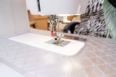 Dikiş makinesini yakından gören bir zanaat atölyesi devam ediyor. İğne aşağıya doğru hareket ediyor, katılımcılar gün boyunca projelerinde çalışırken kumaşı delip geçiyor..