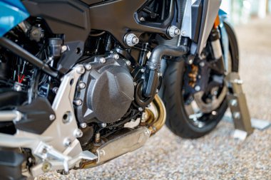 Motosiklet motorunun yakın çekimi karmaşık parçaları ve mühendisliği ortaya çıkarıyor. Ayarlar mekanik bileşenleri vurgulayan doğal ışık ile bir atölye öneriyor.