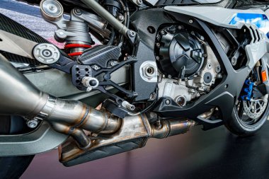 Detaylı görünüm, egzoz ve çerçeve gibi görünür bileşenleri olan yüksek performanslı bir motorun hassas mühendisliğini vurguluyor. Motosiklet meraklıları ve mühendisler için ideal..