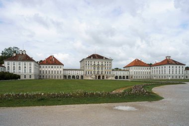 Münih 'te yemyeşil bahçeli görkemli bir saray kompleksi var. Gökyüzü bulutlarla dolu, sakin ve huzurlu bir atmosfer yaratıyor, keşif için ideal..
