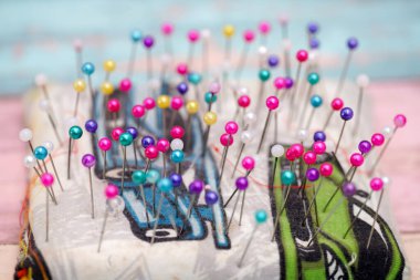 Parlak renkli dikiş iğneleri koleksiyonu bir iğne yastığını eğlenceli bir dizaynla doldurur ve gündüzleri yaratıcı dikiş projeleri için canlı bir atmosferi yansıtır..