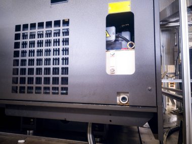 Bir soğutma ünitesi aktif olarak bir gıda işleme tesisinde soğuyor. Kurulumda, makinenin işlevsel durumunu gösteren metal paneller ve görünür iç bileşenler yer alıyor.