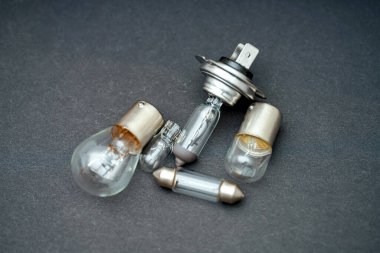 Geleneksel ve otomotiv tipleri de dahil olmak üzere çeşitli ampul stilleri, şekillerini ve tasarımlarını sergileyerek koyu bir zemin üzerinde bir araya getirilmiştir..