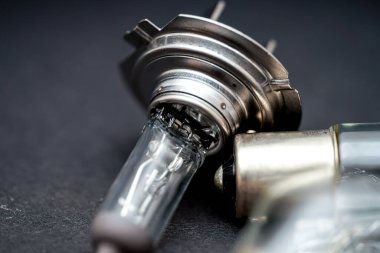 Bu yakın plan metal tabanlı ve cam zarflı bir araba farı ampulünü gösteriyor. Tasarım, işlevi için gerekli olan karmaşık bileşenleri vurgular.