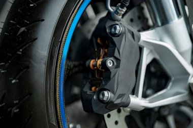 A detailed look at a motorcycle brake caliper highlighting its advanced design and performance features. The image captures the precision and engineering involved in motorcycle braking systems.