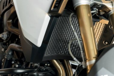 This view highlights the radiator and engine parts of a motorcycle, focusing on their structure, texture, and the materials used for cooling.