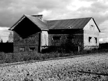 Bilinmeyen bir yerin ortasında, harabelerde duran gizemli, bitmemiş bir ev. Tek renkli fotoğraf..
