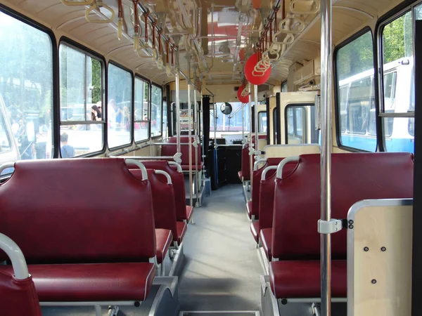 empty interior of public transport bus with maroon seats