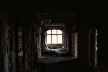 Terk edilmiş koridorun sonunda parlak bir pencere var..