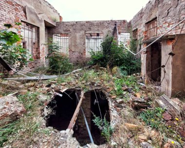 Terk edilmiş bir binanın avlusunda delik.