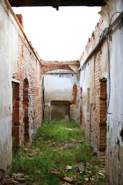 Terk edilmiş bir binanın çatısız koridorundan bak.