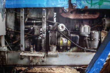 Tamir edilmesi gereken eski bir traktörün yağlı motor mekaniği..