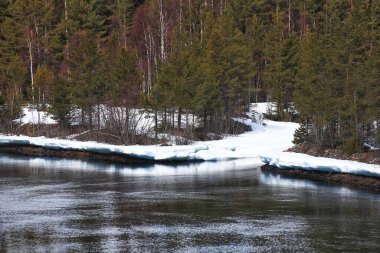 Kuzey İsveç 'te küçük bir haliçle donmuş nehir kenarı..