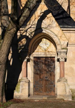 MAGDEBURG, GERMANY - Ocak 01 2024: St Pauls Kilisesi 'nin kapısı güneş ışığı ve gölgeler tarafından çerçevelenmiştir. Yukarıdaki resimde Ich bin das Licht der Welt yazılıdır (Ben dünyanın ışığıyım, John 8: 12 'den itibaren).