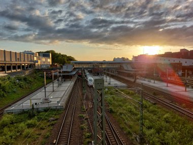 Gün batımında Berlin Gesundbrunnen tren istasyonu Ufukta boş platformlar ve raylarla.
